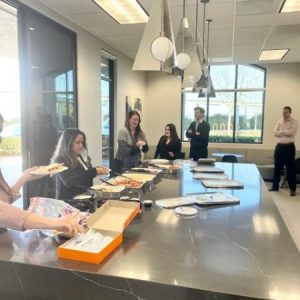 Employees grabbing plates of lunch from office.